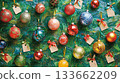 A green background with many colorful Christmas ornaments hanging from it 133662209