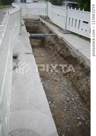 Open Trench with Temporary Fencing at Construction Site 133663259