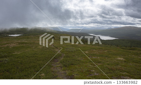 Serene view of Lake Flatningen from Strondsaeterhoe mountain in Vang Municipality, Innlandet County, Norway during cloudy weather 133663982