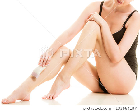 Woman shaving her legs with electric razor 133664197
