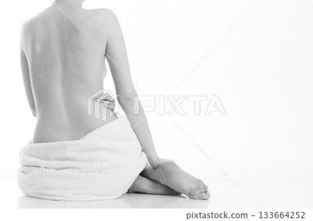 Sitting naked woman in white towel 133664252