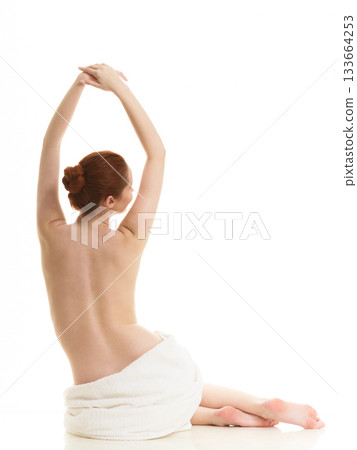 Sitting naked woman in white towel 133664253