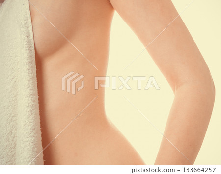 Woman covering breast under towel. Woman covering breast under towel. 133664257