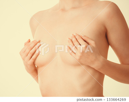 Woman covering her breast with hands 133664269