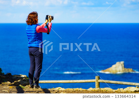 Tourist with camera on Asturias coast, Spain Tourist with camera on Asturias coast, Spain 133664314