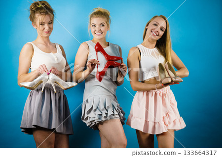 Three women showing high heels shoes Three women showing high heels shoes 133664317