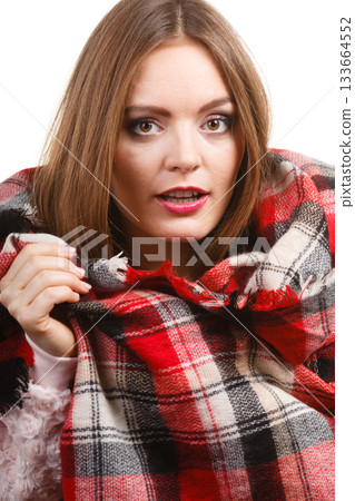 Woman wearing warm scarf warming herself up 133664552