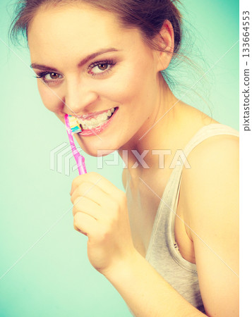 Woman brushing cleaning teeth 133664553
