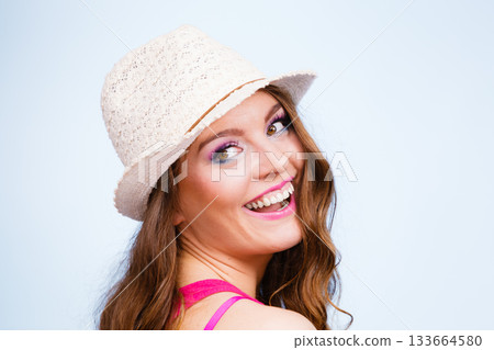 Woman in summer straw hat on head smiling 133664580