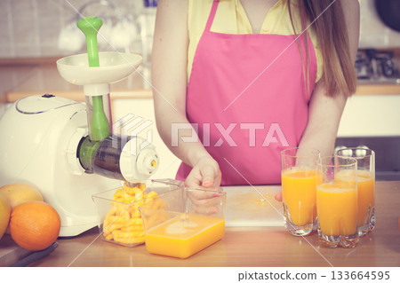 Woman pouring orange juice drink in glass 133664595