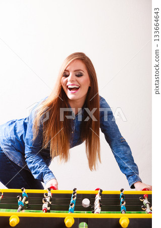 woman playing table football game woman playing table football game 133664643