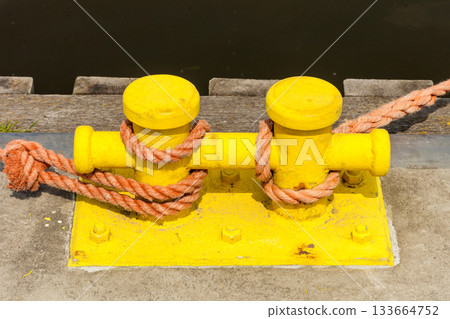 Sailing ropes tied around pins in sunlight Sailing ropes tied around pins in sunlight 133664752