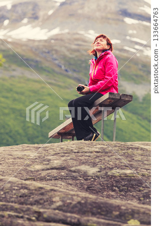 Tourist with camera looking at scenic view in mountains Norway Tourist with camera looking at scenic view in mountains Norway 133664763