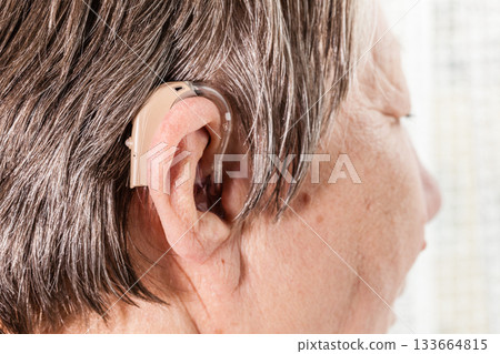 Closeup senior woman using hearing aid Closeup senior woman using hearing aid 133664815