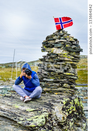 Tourist with camera in Norway mountains Tourist with camera in Norway mountains 133664842