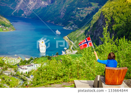 Tourist over Geirangerfjord holds norwegian flag 133664844