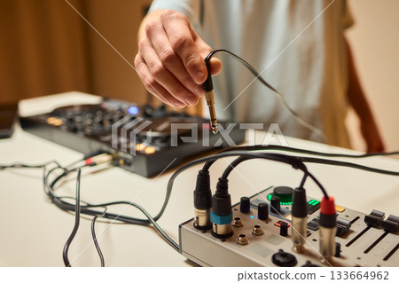 Engineer finetuning sound signals using patch cables, Focused technician adjusting levels on electronic patch cable setup with vivid colorful plugs and tactile interfaces Engineer finetuning sound signals using patch cables, Focused technician adjusting levels on electronic patch cable setup with vivid colorful plugs and tactile interfaces 133664962