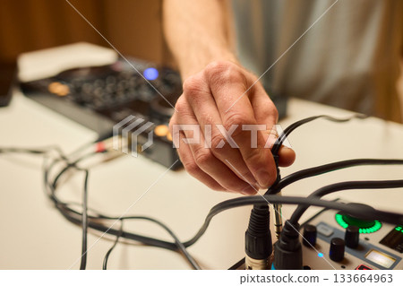Engineer finetuning sound signals using patch cables, Focused technician adjusting levels on electronic patch cable setup with vivid colorful plugs and tactile interfaces Engineer finetuning sound signals using patch cables, Focused technician adjusting levels on electronic patch cable setup with vivid colorful plugs and tactile interfaces 133664963