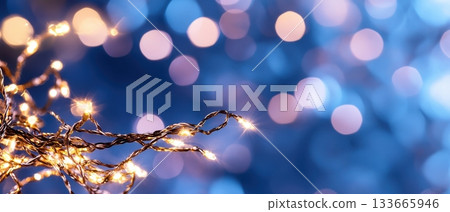 Warm golden lights twinkle on a dark blue background, creating a festive and magical bokeh effect. Horizontal banner with copy space for text, poster, free space 133665946