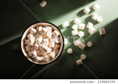 Christmas Bowl of Hot Chocolate with Marshmallows and Pine Branch on Green Background Christmas Bowl of Hot Chocolate with Marshmallows and Pine Branch on Green Background 133666193