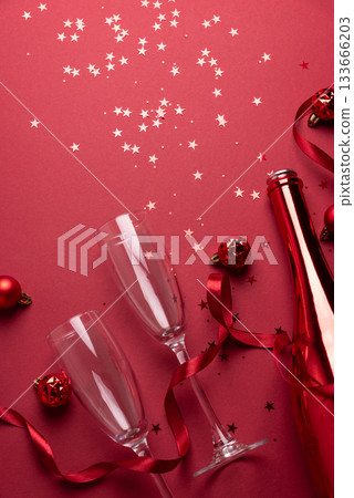 Red Holiday Celebration with Champagne Flutes, Bottle, and Ornaments Red Holiday Celebration with Champagne Flutes, Bottle, and Ornaments 133666203