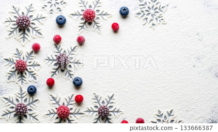Snowflake prints and frozen berries on flour. Culinary background for winter holidays and festive baking. 133666387