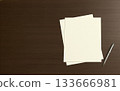 桌上放著深棕色的信紙和原子筆。 133666981