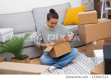 woman in her new home amidst carton boxes, unpacks her aspirations, embodying the possibilities of relocation, renting, or homeownership woman in her new home amidst carton boxes, unpacks her aspirations, embodying the possibilities of relocation, renting, or homeownership 133667121