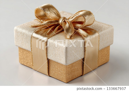 Holiday celebrations. Gold box wrapped with a bow on white background. Jewelry, birthdays, Christmas and luxury branding. 133667937