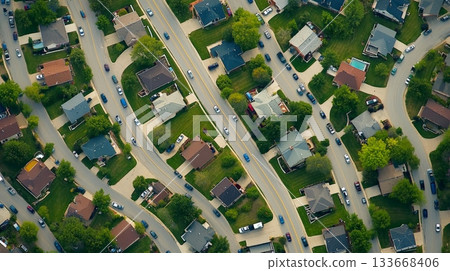 Winding roads weave through a dense residential neighborhood, cars filling the streets in an aerial view showcasing suburban sprawl and transportation patterns Winding roads weave through a dense residential neighborhood, cars filling the streets in an aerial view showcasing suburban sprawl and transportation patterns 133668406