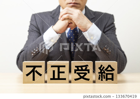 A block with the word "illegal benefits" written on it and a businessman A block with the word "illegal benefits" written on it and a businessman 133670419