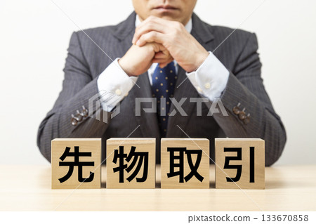 A block with the word "futures trading" written on it and a businessman 133670858