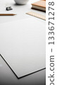 White paper on a desk with pencils, rulers and other stationery, creative mockup material 133671278