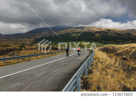 Cyclists on scenic mountain road near Mount Etna, Sicily, Italy 133671603
