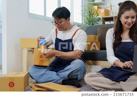 E-commerce Teamwork. Couple packing orders and managing inventory. 133671735