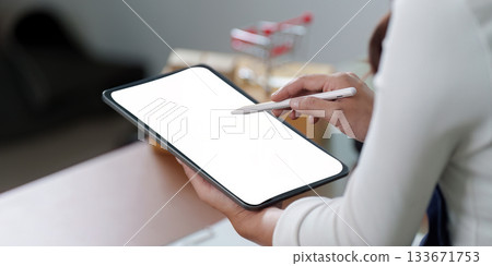 Digital Workspace. Close-up of a woman holding a tablet with a blank screen. Digital Workspace. Close-up of a woman holding a tablet with a blank screen. 133671753