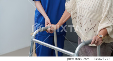 Healthcare. Compassionate caregiver assisting elderly with walker. 133671772