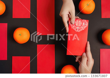 Chinese New Year with red envelopes and oranges on black background 133671807
