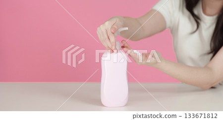 Sustainable skincare. Woman applying lotion from eco-friendly bottle. Sustainable skincare. Woman applying lotion from eco-friendly bottle. 133671812