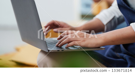 Remote Work. Individual typing on laptop, focused on digital tasks. 133671814
