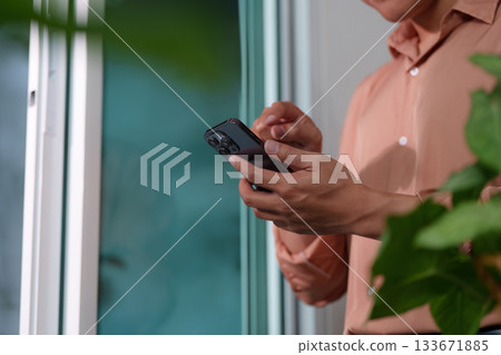 Digital Transformation. Young professional using smartphone for productivity in modern workspace. Digital Transformation. Young professional using smartphone for productivity in modern workspace. 133671885