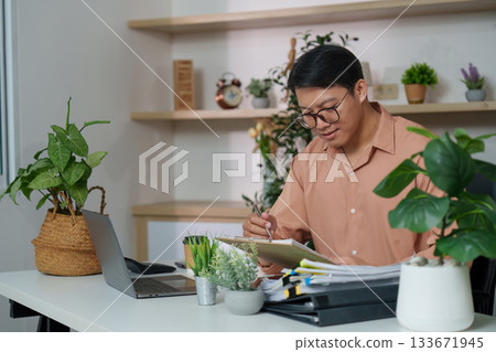 Inclusive Workspace. Young professional engaged in creative work at a modern desk. Inclusive Workspace. Young professional engaged in creative work at a modern desk. 133671945