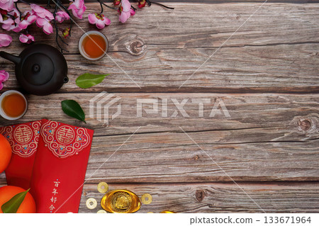 Chinese New Year celebration with tea, oranges, and red envelopes on wooden table Chinese New Year celebration with tea, oranges, and red envelopes on wooden table 133671964