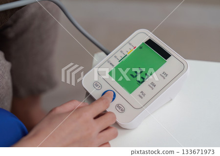Caregiver monitoring health with digital blood pressure monitor 133671973