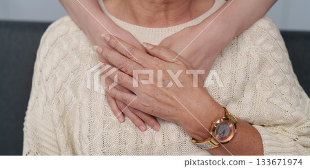 Close-up of caregiver's hands comforting elderly woman 133671974