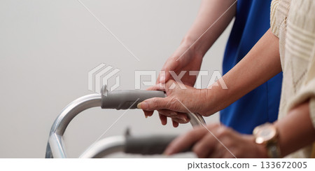 Caregiver assisting elderly with walker for mobility support Caregiver assisting elderly with walker for mobility support 133672005