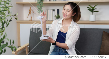 Eco-Friendly Technology. Young woman unboxing renewable energy gadget at home. Eco-Friendly Technology. Young woman unboxing renewable energy gadget at home. 133672057