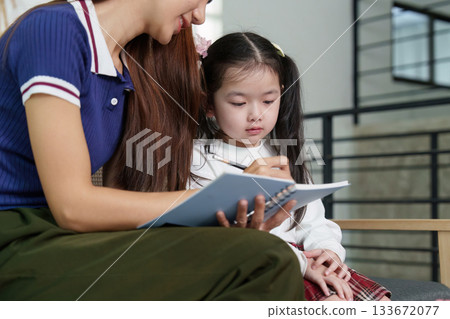Mother and Daughter Learning Together. A mother guides her daughter in writing. Mother and Daughter Learning Together. A mother guides her daughter in writing. 133672077