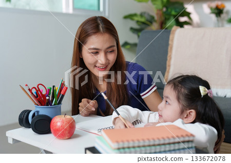 Supportive Learning: Mother Assisting Daughter with Homework Supportive Learning: Mother Assisting Daughter with Homework 133672078