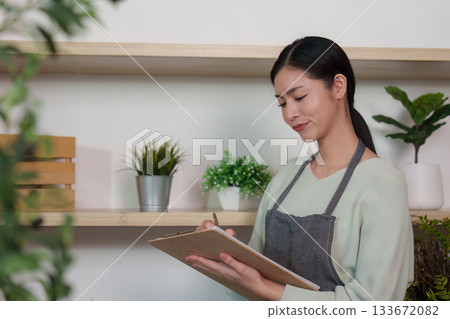 Smiling Young Woman Writing Notes in a Cozy Environment Smiling Young Woman Writing Notes in a Cozy Environment 133672082